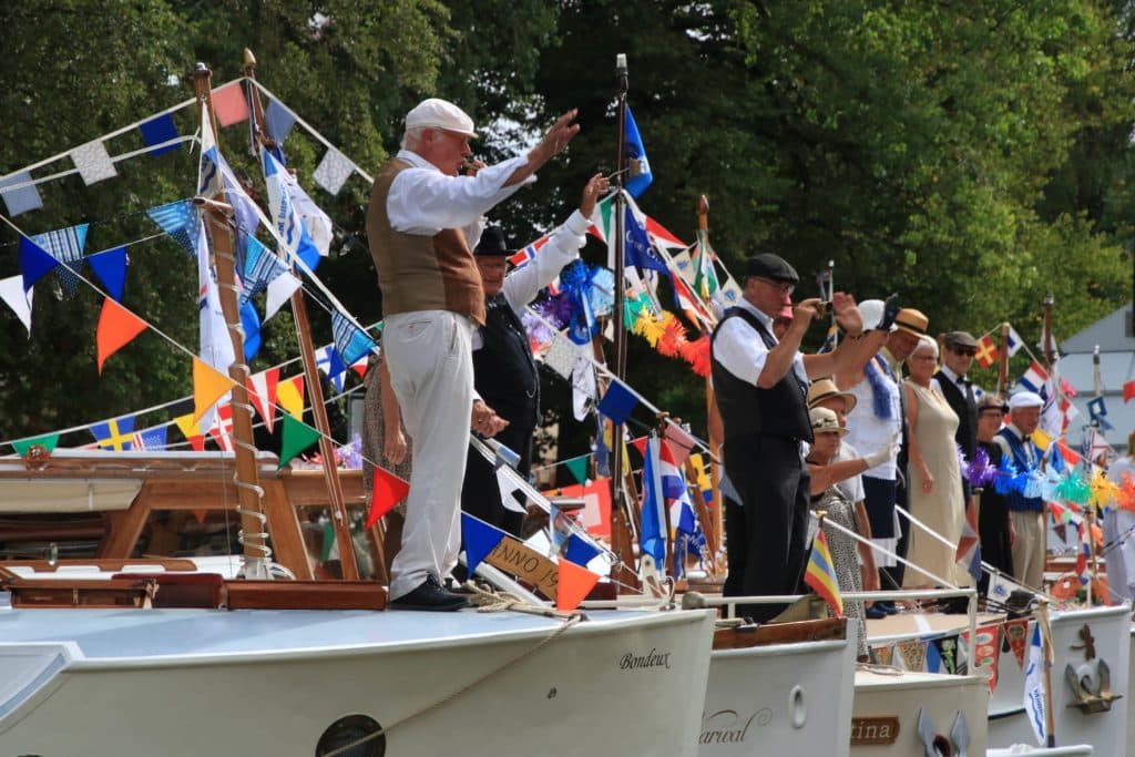 aangemeerde boten met zwaaiende mensen erop - Vereniging Oude Glorie