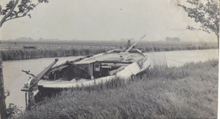 zwart wit foto van een sloep in een rivier