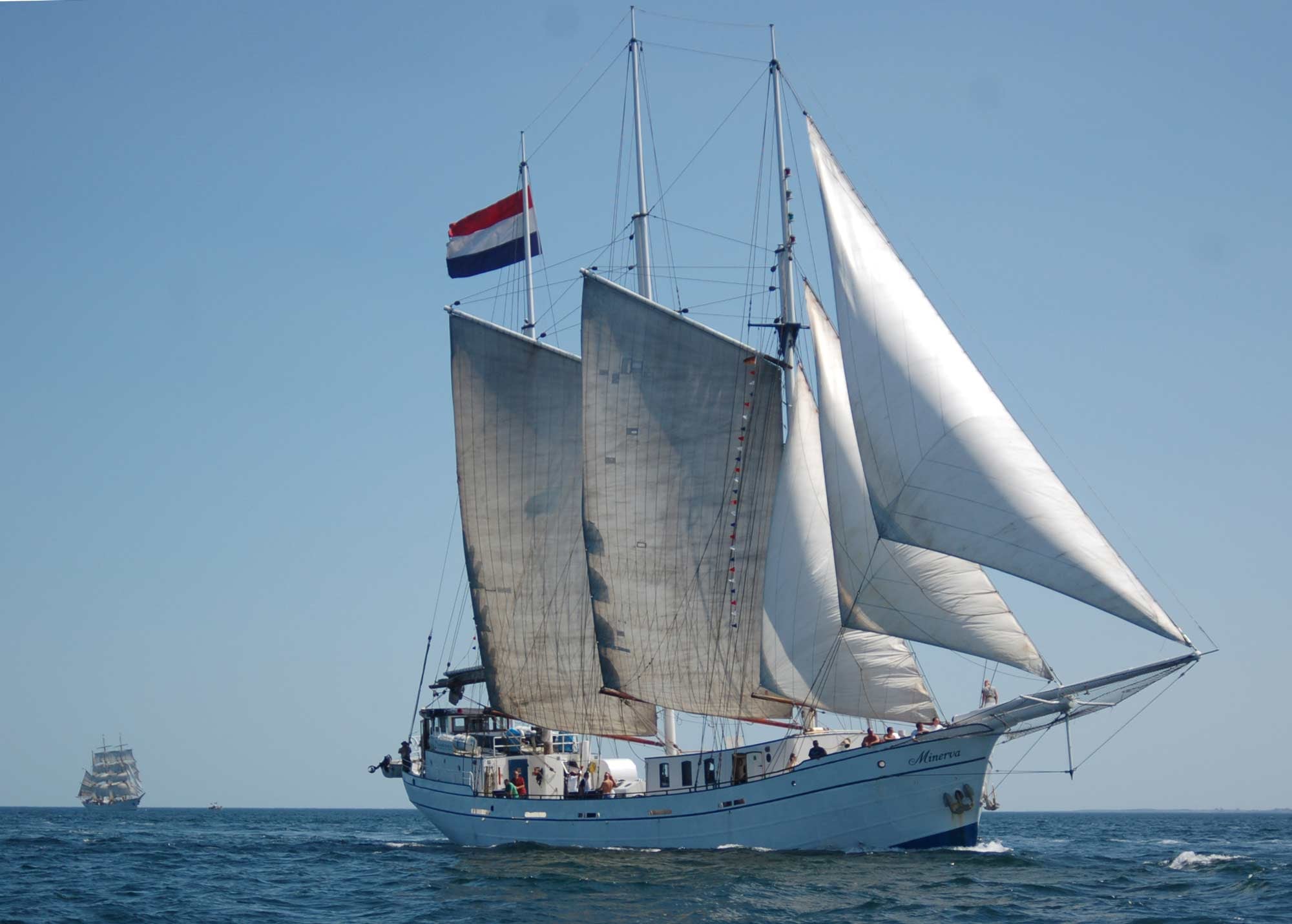 Minerva vaart door de zee met een schip op de achtergrond